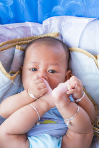 Portrait of cute baby boy lying on bed