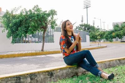 Portrait of a young woman sitting on tree