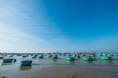 Boats moored on sea against blue sky
