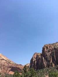 Rock formations on mountain against clear blue sky