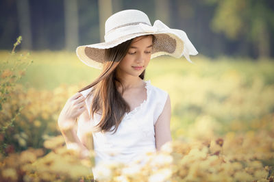 Beautiful young woman wearing hat standing outdoors