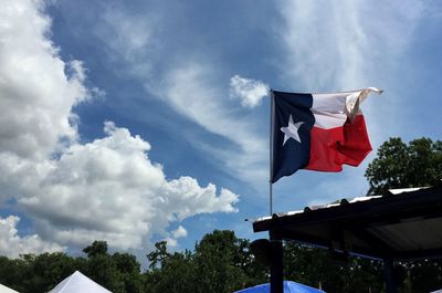 Low angle view of american flag against cloudy sky