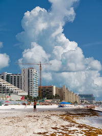 City buildings by sea against sky