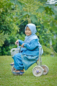 Cute girl in hijab sitting on tricycle