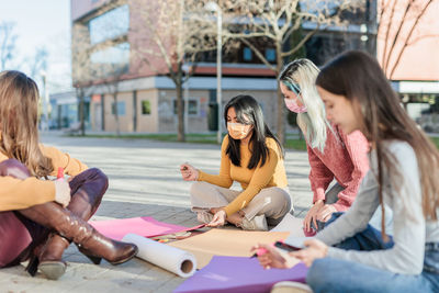 Female friends doing work during protest