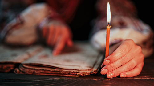 Midsection of woman writing in book