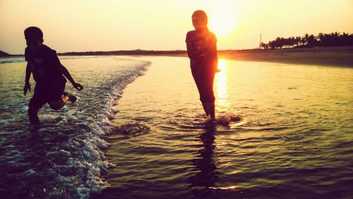 Man on beach against sky during sunset