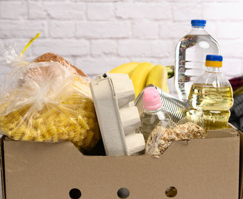 Cardboard box with various products, fruits, pasta, sunflower oil in a plastic bottle and pres