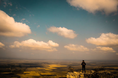 Rear view of man standing by sea against sky