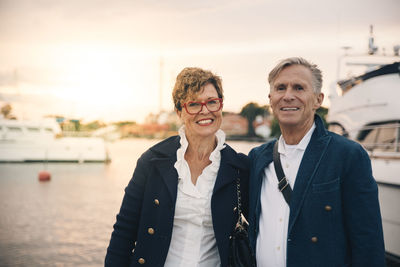 Portrait of confident senior couple smiling at harbor