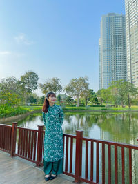 Woman standing by lake against sky