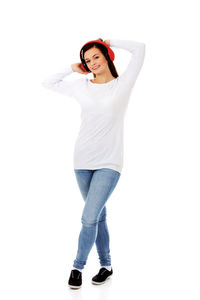 Portrait of smiling young woman standing against white background