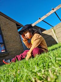 Low angle view of child sitting on the grass 