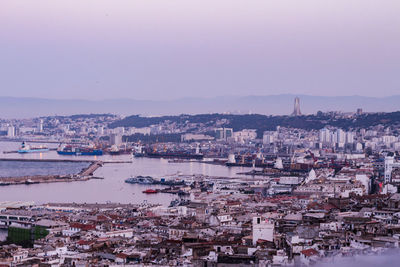 High angle view of townscape by river against sky