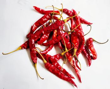 Close-up of red chili peppers on table against white background