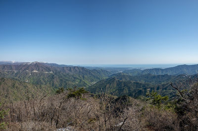 Scenic view of mountains against clear blue sky