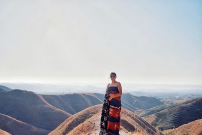 Woman standing on mountain against sky