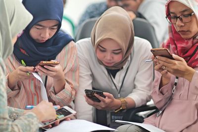 Females wearing hijab using smart phones