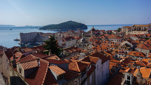 High angle view of townscape by sea against clear sky