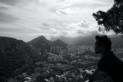 Man looking at city buildings against sky