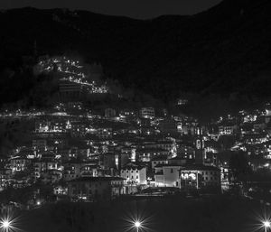 Illuminated cityscape against sky at night