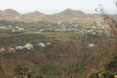 Houses on field by mountains against sky