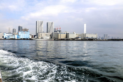 View of city by sea against sky