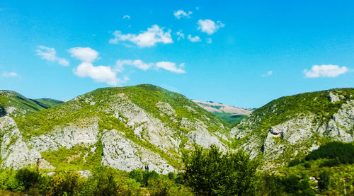 Scenic view of mountains against blue sky