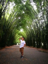 Rear view of woman walking on footpath in forest