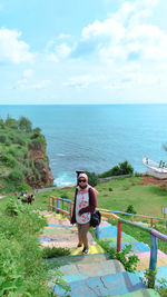 High angle view of woman wearing hijab standing by railing against sea