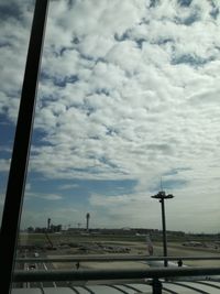 Street against sky seen through glass window