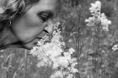 Portrait of beautiful woman against red flowering plants