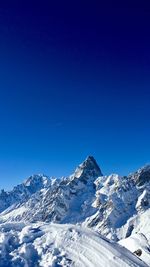 Scenic view of snowcapped mountains against clear blue sky