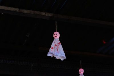 Low angle view of pink decoration hanging at night