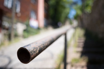 Close-up of metallic railing by sidewalk