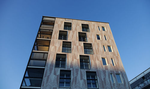 Low angle view of modern building against clear blue sky