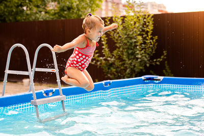 Boy jumping in swimming pool