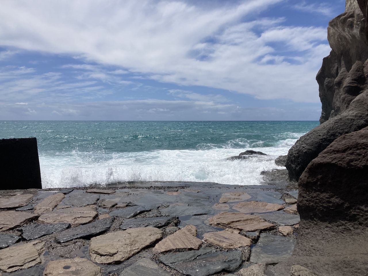 rock, sea, water, sky, land, beach, shore, ocean, coast, scenics - nature, nature, cloud, terrain, beauty in nature, cliff, horizon over water, horizon, wave, body of water, vacation, no people, motion, day, sand, outdoors, bay, tranquility, travel destinations, environment, tranquil scene, travel, sports