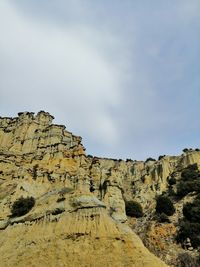 Low angle view of rocks against sky