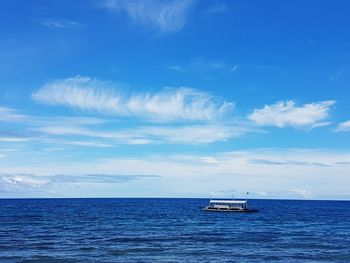 Sailboat sailing on sea against blue sky