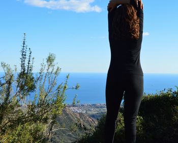 Rear view of woman overlooking calm sea