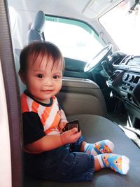 Portrait of cute girl sitting in car