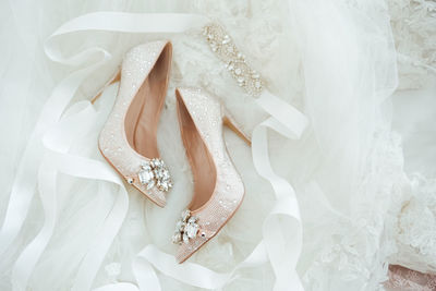 Close-up of wedding shoes dainty beautiful flatlay details stillettos lace background crystals