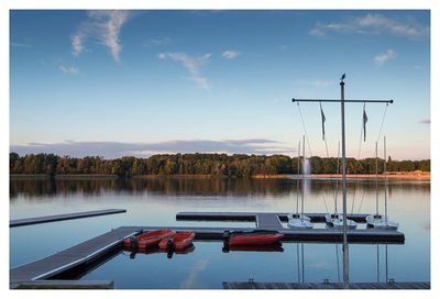 View of boats in calm lake against mountain range