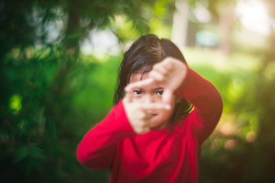 Portrait of cute girl making frame with hands