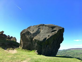 Rock formations on landscape against clear blue sky