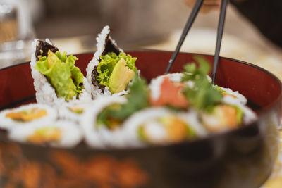 Close-up of person holding sushi on table