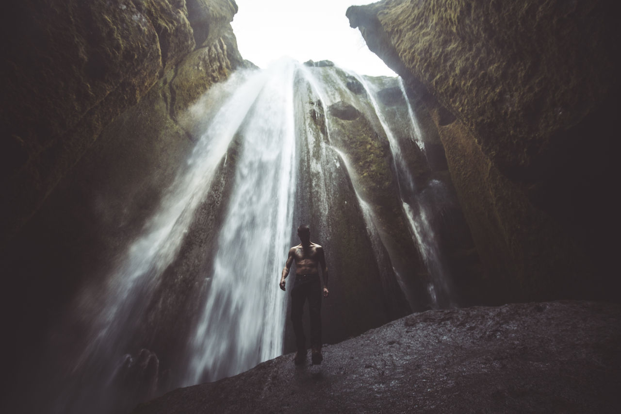 PANORAMIC VIEW OF WATERFALL ALONG ROCKS