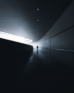 Mid distance of silhouette man walking in tunnel