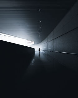 Man walking in illuminated tunnel